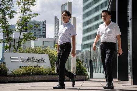 Pedestrians walk outside the headquarters of Japanese company SoftBank Group in Tokyo on August 7, 2024. (AFP)