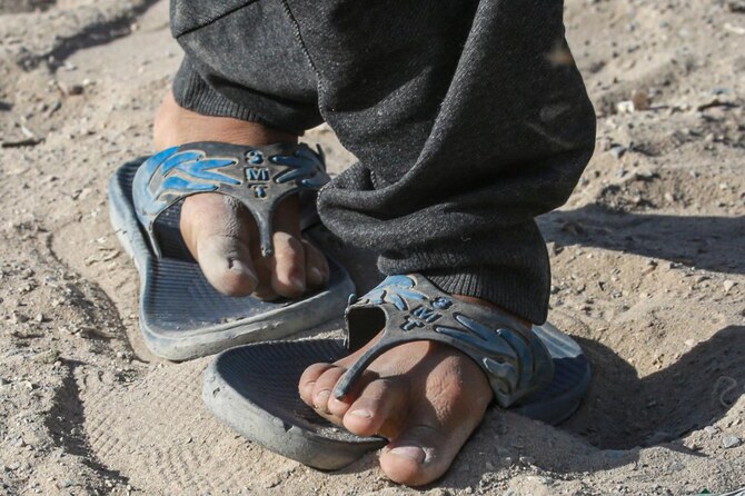 A Palestinian shows his damaged shoes in Khan Yunis, on the southern Gaza Strip on July 6, 2024, amid the ongoing conflict between Israel and the militant Hamas group. Finding shoes and clothing has become increasingly difficult for the 2.4 million people living in the Palestinian territory besieged by Israel. (AFP)
