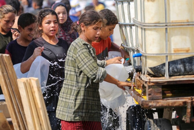 People line up to fill containers with water at a makeshift camp for displaced Palestinians in Deir al-Balah in the central Gaza Strip on August 19, 2024, amid the continuing conflict between Israel and Hamas group. (AFP)