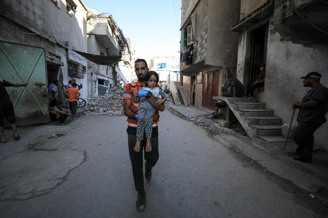 A civil defence worker carries a girl at a school site, which was sheltering displaced people, after it was hit by an Israeli strike, in Gaza City, September 1, 2024. (Reuters)