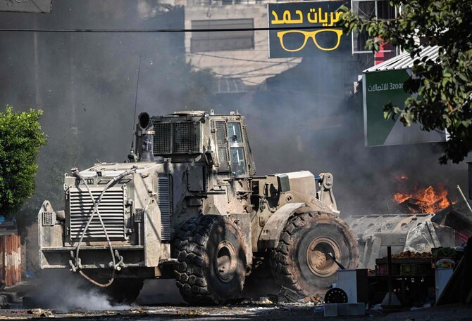 An Israeli bulldozer drives as fire breaks out in a fruit market in the occupied West Bank city of Jenin amid ongoing Israeli raids on Aug. 31, 2024. (AFP)