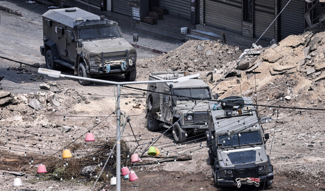 Israeli army armoured vehicles move along an excavated section of a road in the centre of Jenin in the occupied West Bank on September 5, 2024. (AFP)