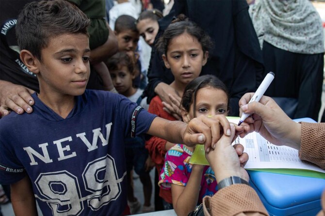 A child has his finger marked after receiving a vaccination for polio at a make-shift camp for people displaced by conflict in a school run by the UNRWA in Khan Yunis on Sept. 5, 2024. (AFP)