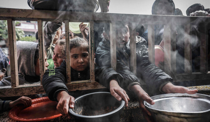 Displaced Palestinian children gather to receive food at a government school in Rafah in the southern Gaza Strip on February 19, 2024, amid the ongoing battles between Israel and the militant group Hamas. (AFP)