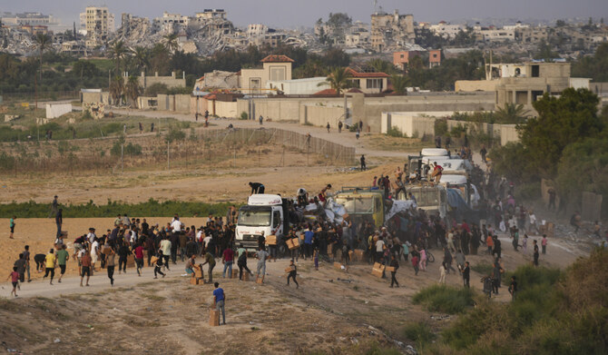 Palestinians are storming trucks loaded with humanitarian aid brought in through a new U.S.-built pier, in the central Gaza Strip, May 18, 2024. (AP)