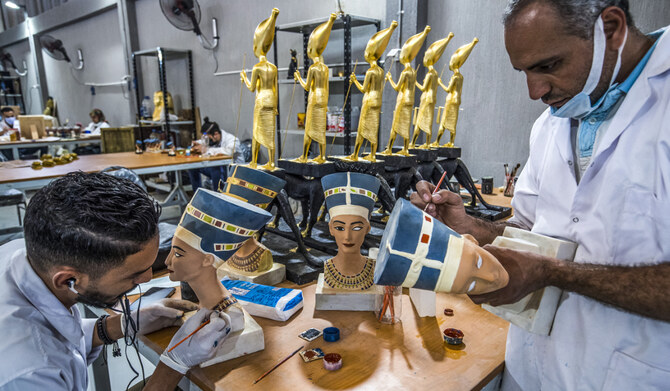 Technicians paint replicas of Ancient Egyptian busts of Queen Nefertiti being fabricated at the Egyptian government's Konouz (Treasures) factory reproducing replicas of Ancient Egyptian items, at el-Obour city, east of the capital Cairo on May 17, 2021. (AFP)