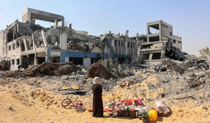 A woman looks around as she salvages items at the damaged UN Relief and Works Agency for Palestine Refugees (UNRWA) building complex in western Gaza City's Al-Sinaa neighbouhood on July 12, 2024, following the withdrawal of Israeli troops from the area amid the ongoing conflict between Israel and the Hamas group in the besieged Palestinian territory. (AFP)