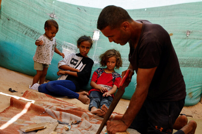 Palestinian Saber Dawas crafts wooden sandals due to a shortage of footwear in the enclave and the lack of financial means to afford those which are available in the market, in Khan Younis on Sept. 9, 2024. (Reuters)
