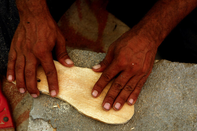 Palestinian Saber Dawas crafts wooden sandals due to a shortage of footwear in the enclave and the lack of financial means to afford those which are available in the market, in Khan Younis on Sept. 9, 2024. (Reuters)