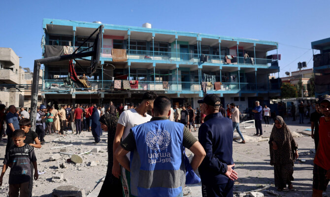 A member of the United Nations Relief and Works Agency for Palestine Refugees (UNRWA) checks the courtyard of a school after an Israeli air strike hit the site, in Nuseirat in the central Gaza Strip on September 11, 2024, amid the ongoing war in the Palestinian territory between Israel and Hamas. (AFP)
