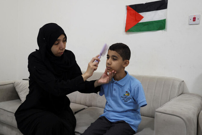 Mahmoud Ajjour, an injured child evacuated from Gaza, sits at home with his mother as she prepares him for school, in Doha, Qatar, September 10, 2024. (REUTERS)