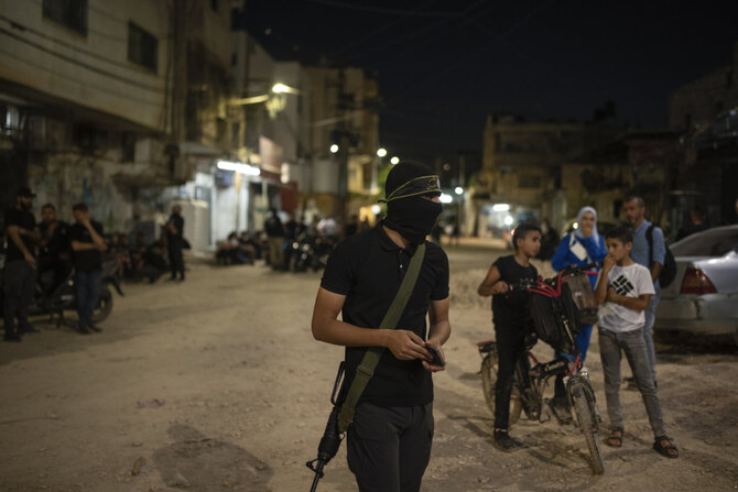 Young Palestinians are seen approaching a militant outside a mosque in Jenin, West Bank, on June 6, 2024. (AP)