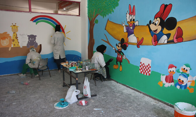 Women paint murals inside one of the classrooms of a school used as a shelter for displaced Palestinians in Gaza City's Al-Shati refugee camp in the northern Gaza Strip on September 12, 2024. (AFP)