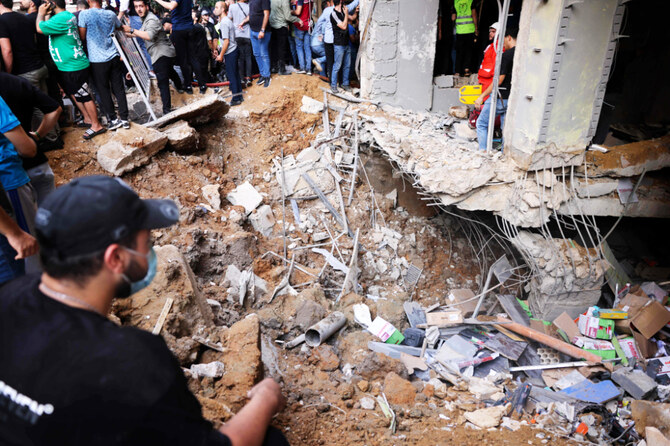 People and first responders gather in front of a building targeted by an Israeli strike in Beirut's southern suburbs on September 20, 2024. (AFP)