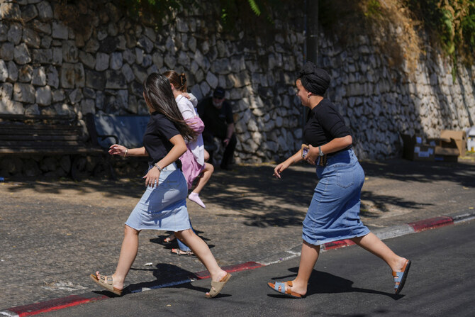 Israelis run to take cover in Safed, northern Israel, as a siren sounds a warning of incoming rockets fired from Lebanon, on Sept. 26, 2024. (AP Photo)