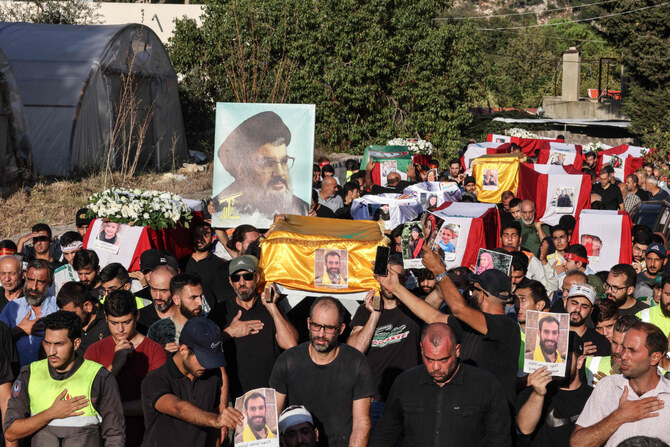 Lebanese mourners carry a portrait of slain Hezbollah chief Hassan Nasrallah during a funeral march for 16 people who were killed in Israeli strikes in the Mount Lebanon village of Maaysra on Sept. 27, 2024. (AFP)