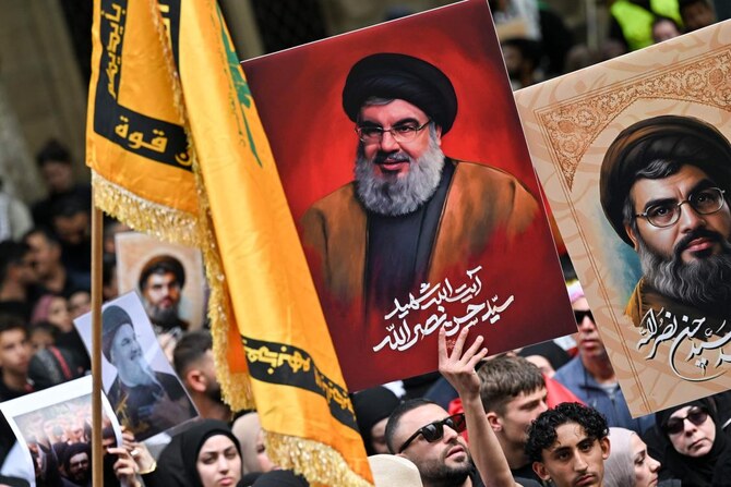 Demonstrators hold flags and pictures of Hassan Nasrallah, late leader of the Lebanese group Hezbollah, at a protest rally in the central business district of Sydney on September 29, 2024. (AFP)