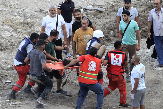 Rescue workers carry a man who was injured after an Israeli airstrike hit two adjacent buildings, in Ain el-Delb neighbourhood east of the southern port city of Sidon, Lebanon. (AP)