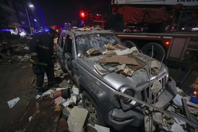 Policemen and civil defense workers inspect a damaged car near a building that was hit in an Israeli airstrike in Beirut, Lebanon, early Monday, Sept. 30, 2024. (AP)