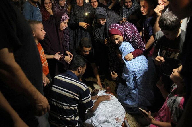 People mourn over the body of a loved one killed during an Israeli strike on the Amr Ibn al Aas school housing displaced Palestinians in the Sheikh Radwan neighborhood in Gaza City on Sept. 7, 2024. (AFP)