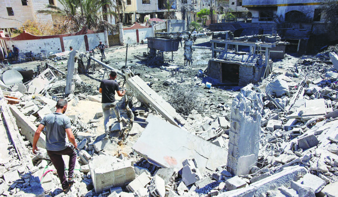 Palestinians walk amid the rubble of a building leveled by Israeli bombing in Gaza City amid the ongoing war between Israel and Hamas. (AFP)