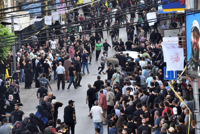 People react after a reported device explosion occurred during the funeral of people killed when hundreds of paging devices exploded across Lebanon the previous day, in Beirut’s southern suburbs on September 18, 2024. (AFP)