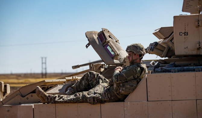 A US soldier rests on a tank as troops patrol oil fields near Syria's northeastern border with Turkey in the Qahtaniyah countryside in the far northeast corner of Hasakeh province on September 3, 2024. (AFP)