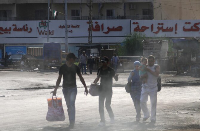 Residents carry their belongings as they flee their homes at the Bab al-Tebbaneh neighbourhood in Tripoli, northern Lebanon, early Sunday as sectoral fighting erupted overnight. (Reuters)