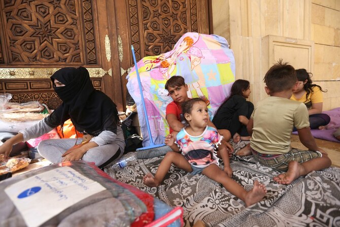 Internally displaced people take shelter outside the Mohammed al-Amin mosque in downtown Beirut on October 2, 2024.(AFP)