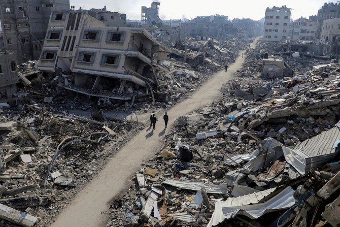 Palestinians walk past destroyed houses, amid the ongoing conflict between Israel and Hamas, in Jabalia refugee camp, in the northern Gaza Strip. (File/Reuters)