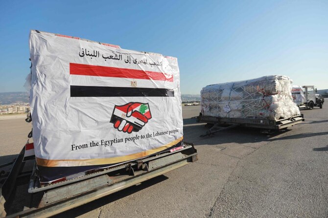 Airport workers transport humanitarian aid, provided by Egypt, at Lebanon’s Beirut international airport on Oct. 5, 2024. (AFP)