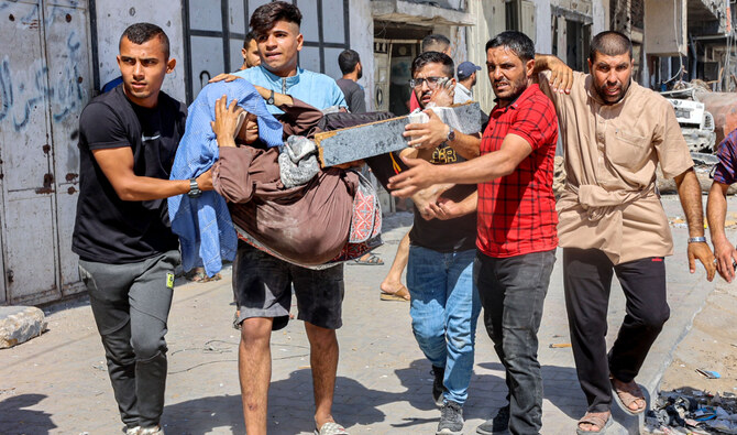 Men carry injured woman to be evacuated in the Jabalia camp for Palestinian refugees in the northern Gaza Strip on October 9. (AFP)