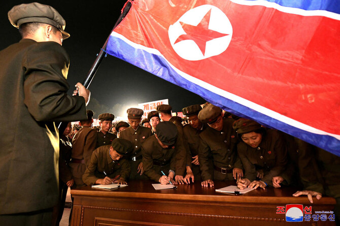 Young people, including students and youth league officials, sign petitions to join or return to the army this week at an undisclosed location in North Korea. (Reuters)
