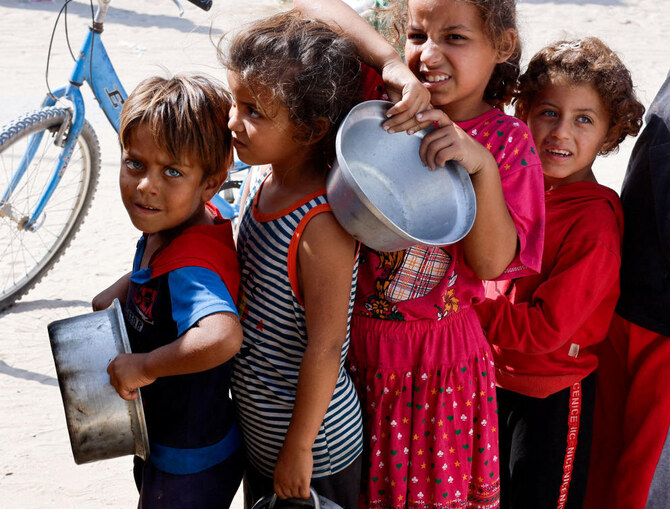 Palestinian children queue to receive food cooked by a charity kitchen, amid the Israel-Hamas conflict, in Khan Younis in the southern Gaza Strip, October 16, 2024. (REUTERS)