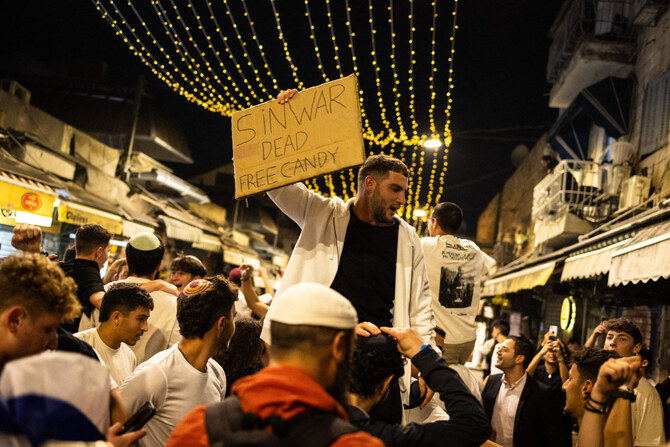 People hold placards as they celebrate in Jerusalem on October 17, 2024, after the Israeli military confirmed the death of Hamas leader Yahya Sinwar. (AFP)
