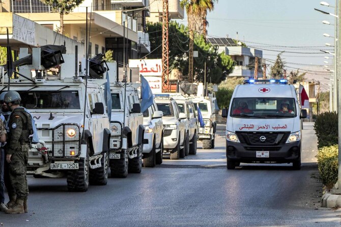 A Lebanese Red Cross ambulance moves past armored vehicles of the United Nations Interim Force in Lebanon during their patrol around Marjayoun in south Lebanon on Oct. 8, 2024. (AFP)