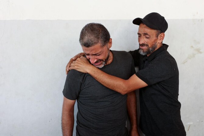 Men mourn relative in the courtyard of the al-Maamadani hospital, where the victims of a reported Israeli strike that hit a UN school-turned-refuge in the Al-Shati refugee camp near Gaza City in the northern Gaza Strip were transported. (File/AFP)