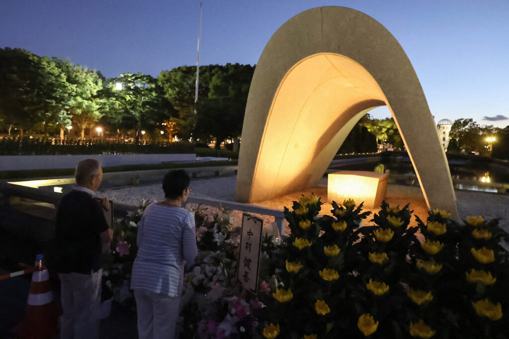 People visit and say prayers at sunrise at the cenotaph for the atomic bomb victims at the Peace Memorial Park in Hiroshima on August 6, 2023, to mark the 78th anniversary of the world's first atomic bomb attack. (AFP)