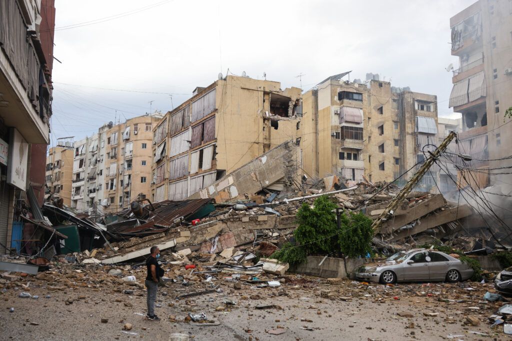 A man looks at the destruction at the site of an overnight Israeli airstrike on the Bir el-Abed neighbourhood in Beirut's southern suburbs on October 1, 2024. (AFP)