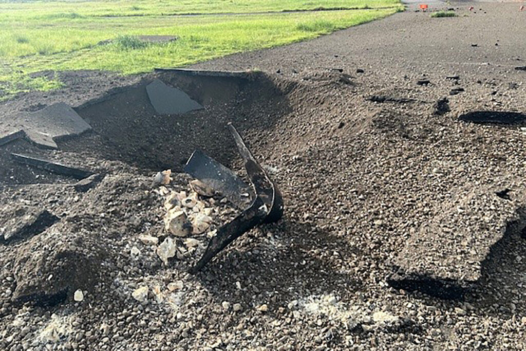 Debris on the edge of the airport tarmac after an unexploded World War II US bomb blew up less than a minute after a passenger jet taxied past on Oct. 2 at Miyazaki airport in southern Kyushu island. (AFP)