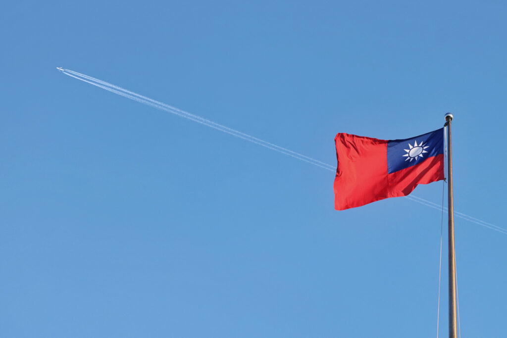 An airplane flies above Taiwan's national flag as it flutters in the wind on the Democracy Boulevard at the Chiang Kai-shek Memorial Hall in Taipei on October 15, 2024. (AFP)