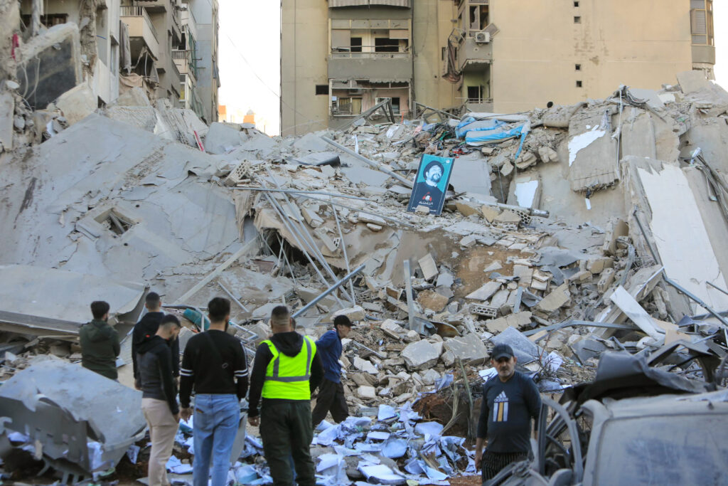 People inspect the damage at the site of an overnight Israeli airstrike that targeted a branch of the Al-Qard Al-Hassan finance group in Beirut’s southern suburbs on October 21, 2024. (AFP)