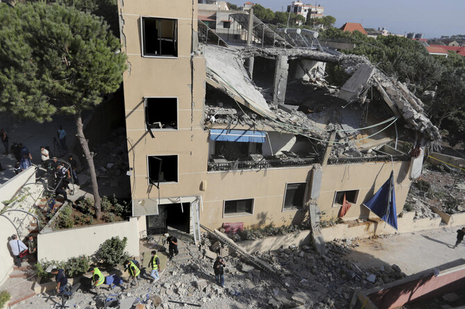 Rescue workers walk outside a hotel-turned-shelter for displaced people hit by an Israeli airstrike, in Wardaniyeh, south Lebanon, Oct. 9, 2024. (AP)