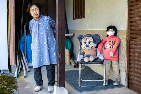 This photo taken on October 21, 2024 shows Hisayo Yamazaki standing next to the puppets outside her house in the village of Ichinono in the city of Tamba-Sasayama, Hyogo Prefecture. (AFP)