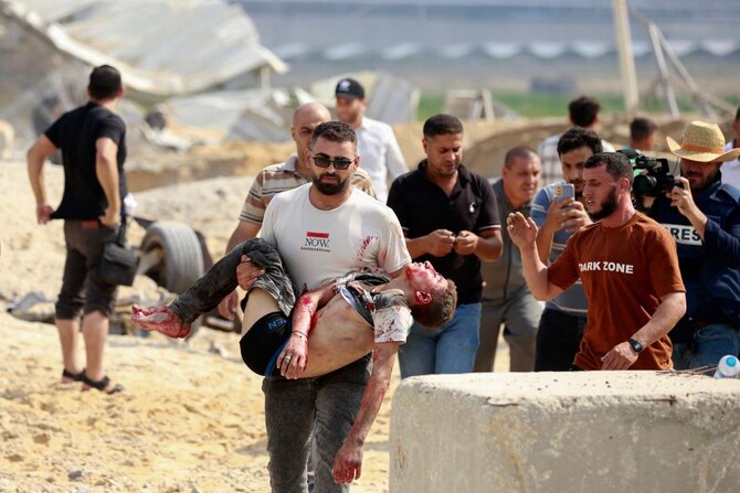 A man carries away a Palestinian killed in an Israeli airstrike at the Erez crossing between Israel and the northern Gaza Strip on Oct. 7, 2023. (AFP)
