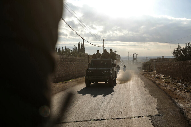 Fighters from Hayat Tahrir Al-Sham ride in military vehicles in the eastern outskirts Atarib in Syria's northern province of Aleppo on Nov. 27, 2024, during clashes with the Syrian army. (AFP)