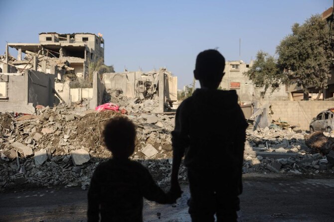 Children stare at the destruction following an Israeli strike in the Nuseirat refugee camp in the central Gaza Strip on November 7. (AFP)