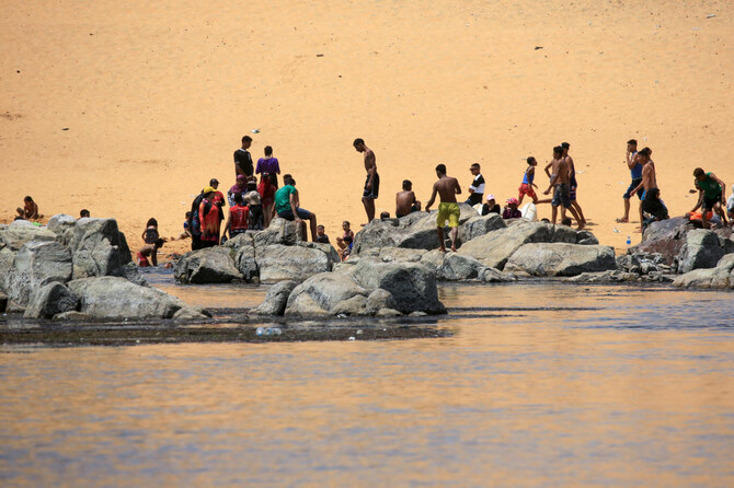 Sudanese who fled the war in their country cool off on the banks of the Nile river in the Egyptian city of Aswan. (File/AFP)