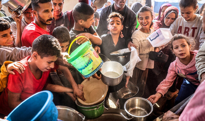 Palestinians collect aid food at Bureij refugee camp in the central Gaza Strip, on November 6, 2024. (AFP/File)