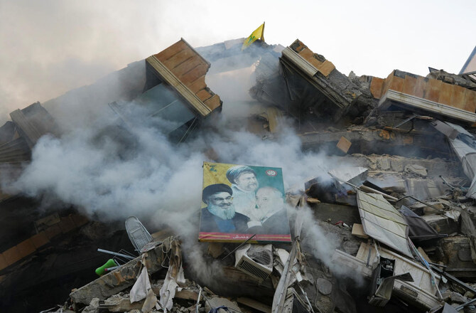 A poster depicting late Hezbollah leader Hassan Nasrallah, Parliament Speaker Nabih Berri and the founder of the Shiite Amal movement Imam Musa Al-Sadr, is placed on the rubble of damaged building, in the aftermath of Israeli strikes on Beirut’s southern suburbs on Nov. 14, 2024. (Reuters)